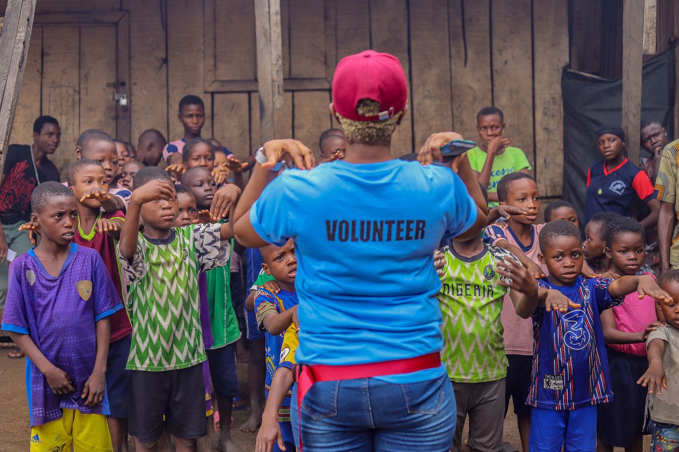A volunteer guiding children during a community education activity